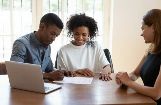 couple with laptop signing papers