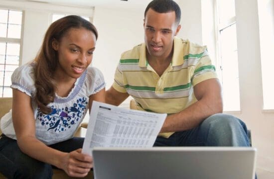 couple with laptop reviewing document