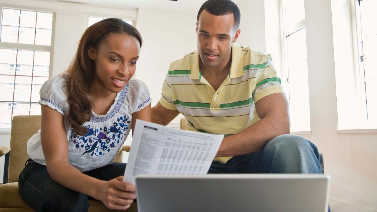 couple with laptop reviewing document