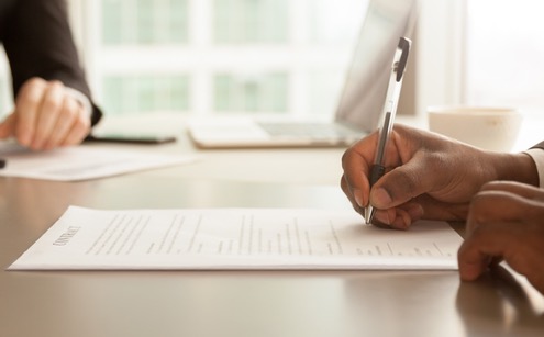 man signing papers